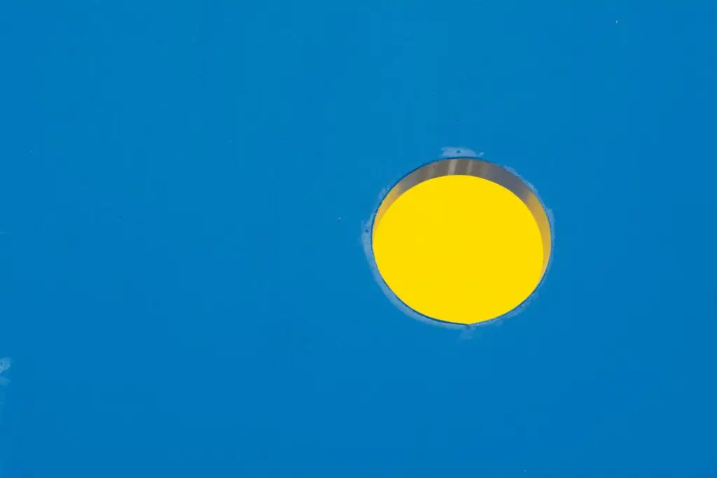 A vibrant yellow circle is set against a solid blue backdrop, creating a striking visual contrast. example of design principle contrast.